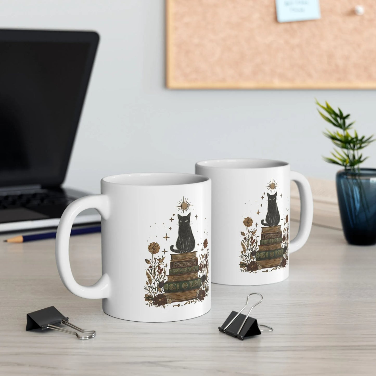 Two Mystic Cat & Books Mugs featuring a black cat atop vintage books surrounded by celestial designs, perfect for cozy reading moments.
