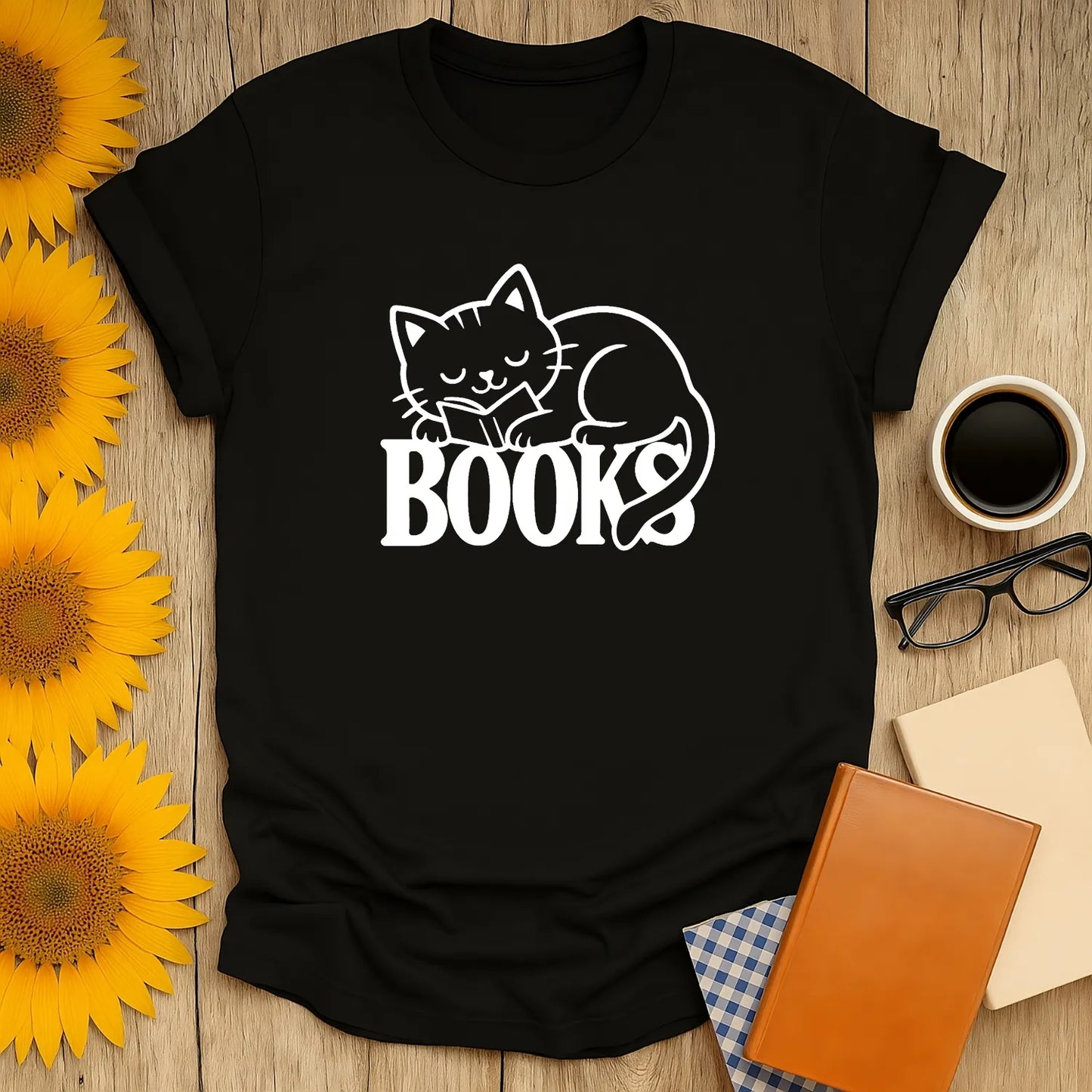 Cozy black t-shirt featuring a sleeping cat on the word 'BOOKS', perfect for book lovers and cat enthusiasts.
