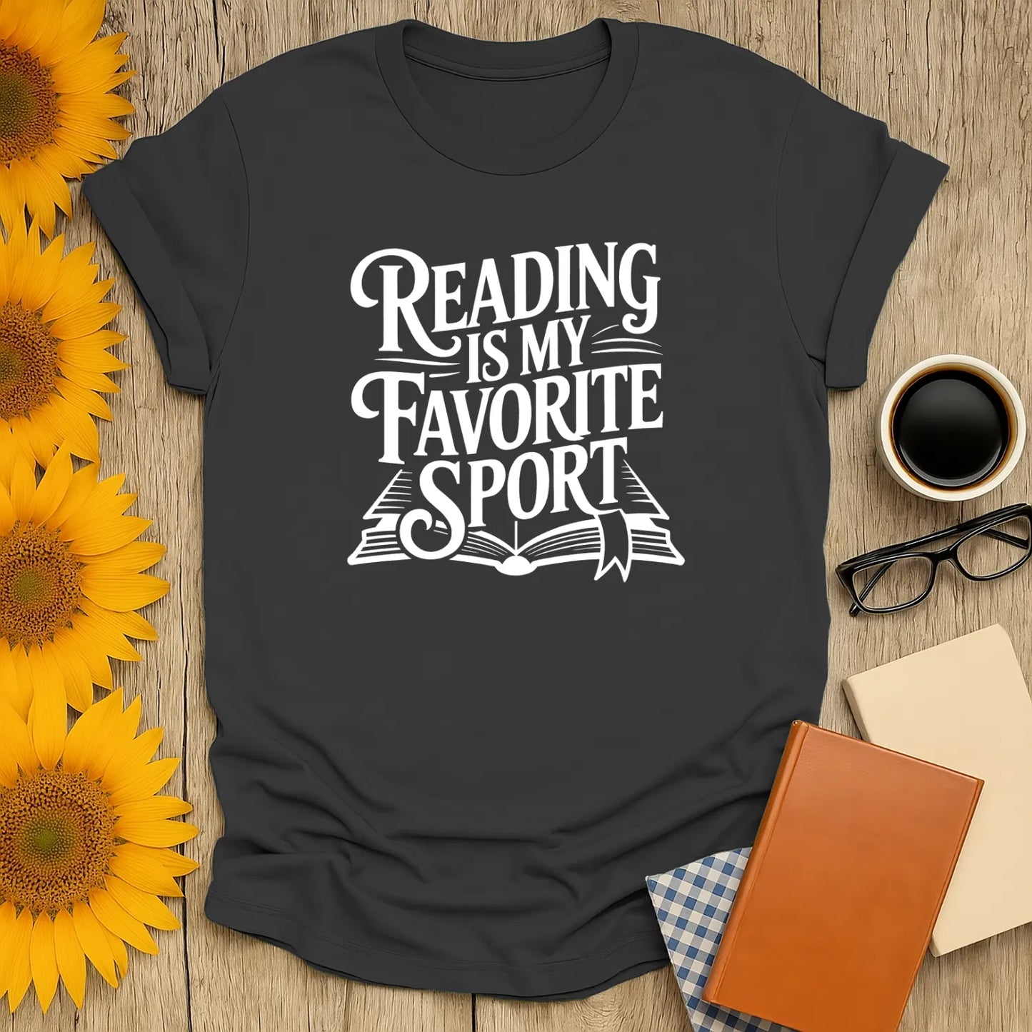 A cozy book lover shirt with 'Reading is My Favorite Sport' in playful font, perfect gift for bookworms enjoying tea or cats.