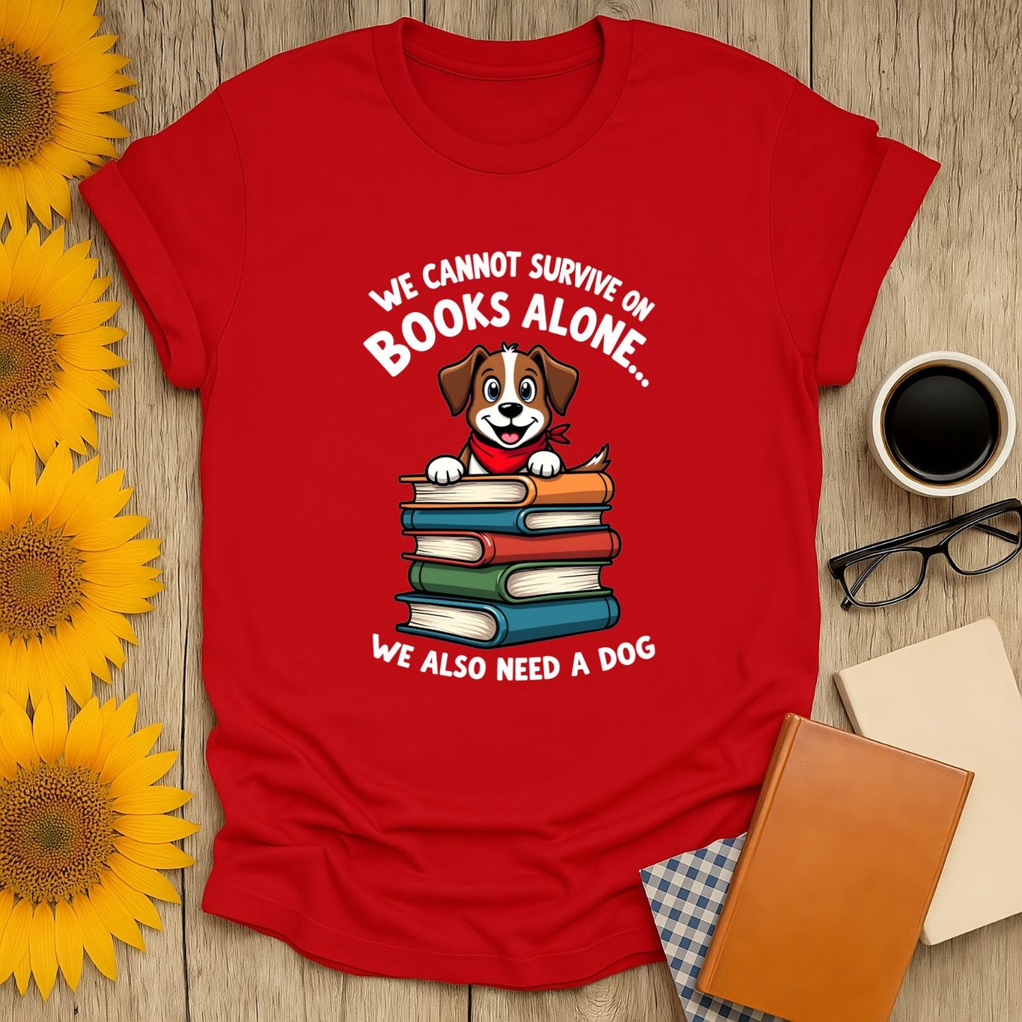 Cozy red shirt featuring a cute dog atop book stacks with the text 'We cannot survive on books alone... We also need a dog.' Perfect for book lovers!
