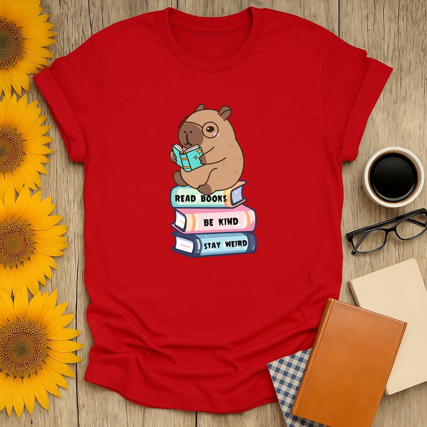 Cozy Capybara Reader T-Shirt featuring a cute capybara with a book and text: 'Read Books, Be Kind, Stay Weird'. Perfect gift for book lovers!