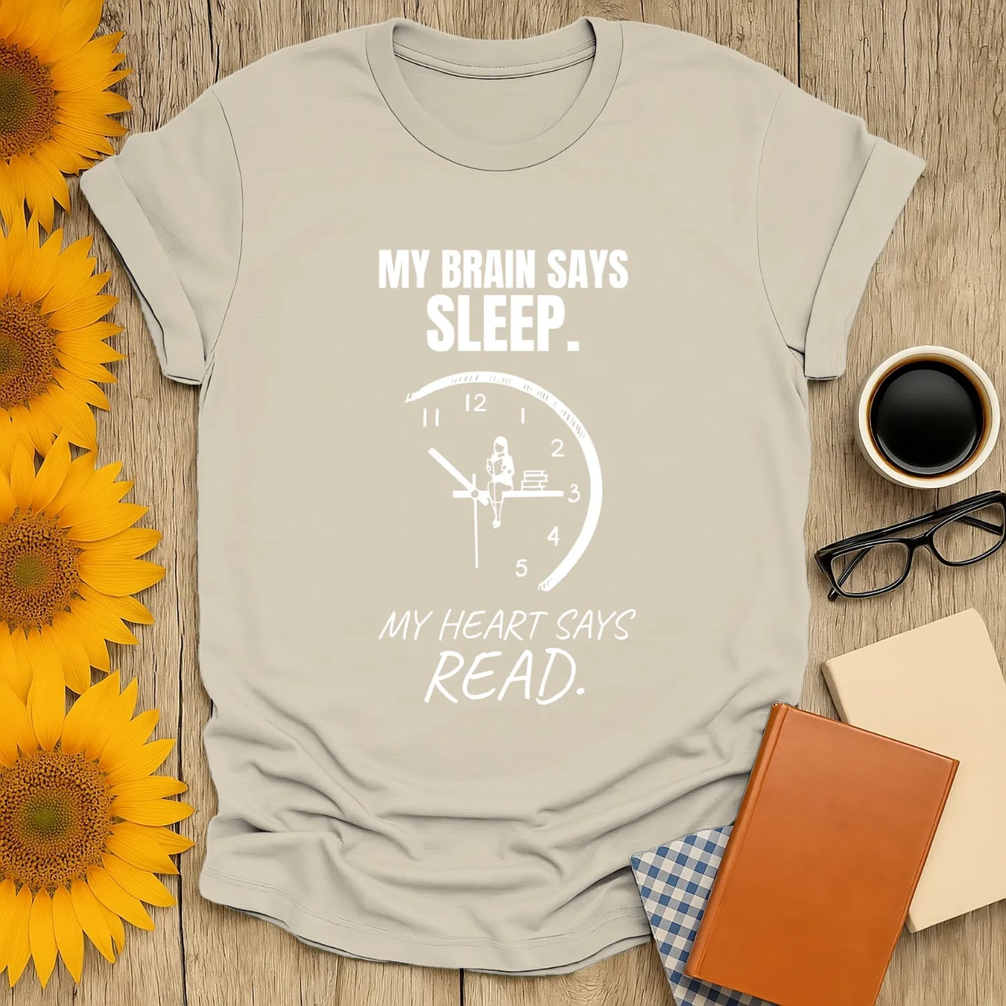 Cozy shirt with a clock, reading girl, and text: "My brain says sleep, my heart says read"; perfect for book lovers.