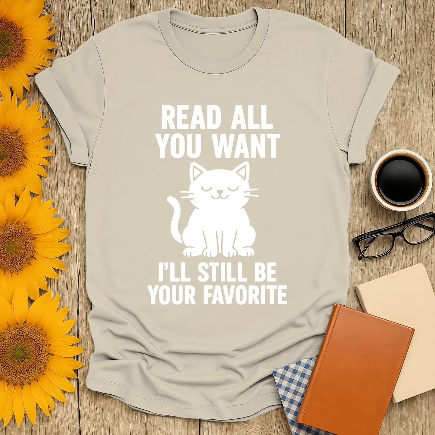 Funny t-shirt for book lovers: a smiling cat with text "Read All You Want, I'll Still Be Your Favorite" – perfect gift for cat and book fans.