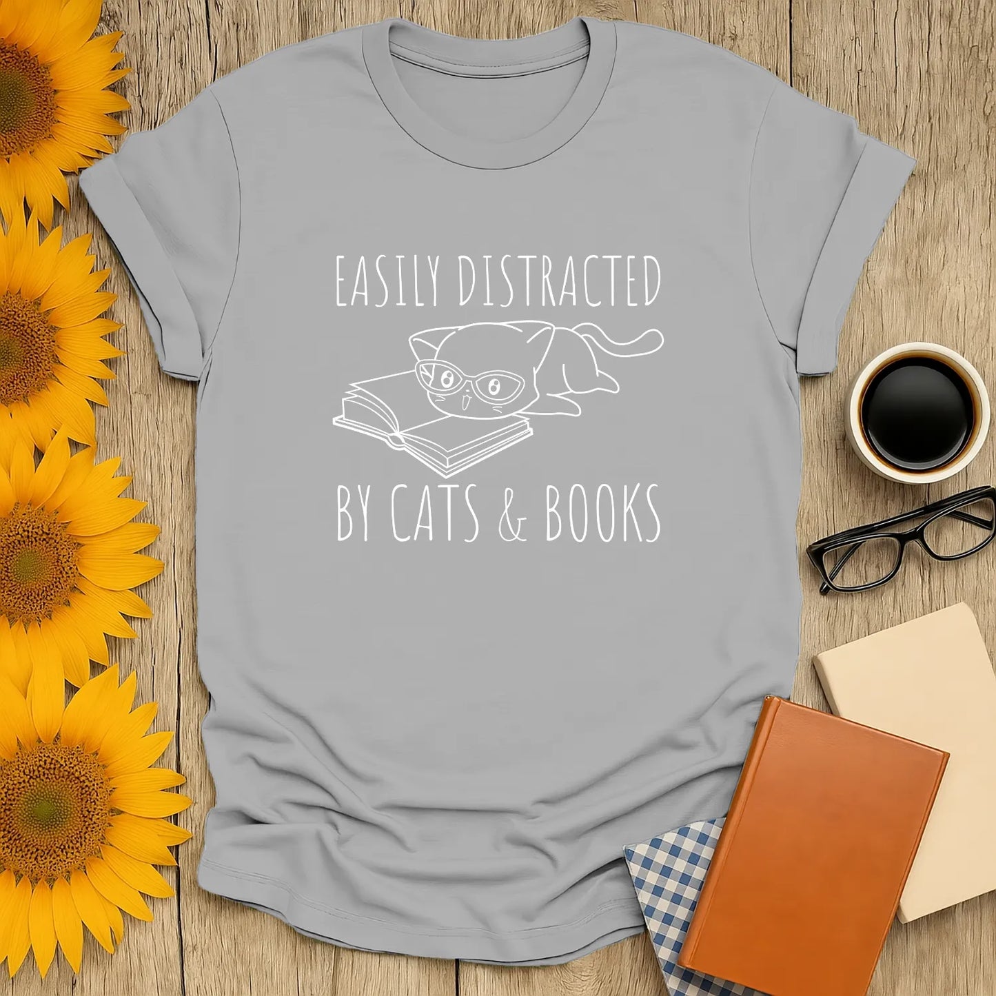 Funny reading tee featuring a glasses-wearing cat lounging on a book, with the text 'Easily Distracted by Cats & Books'