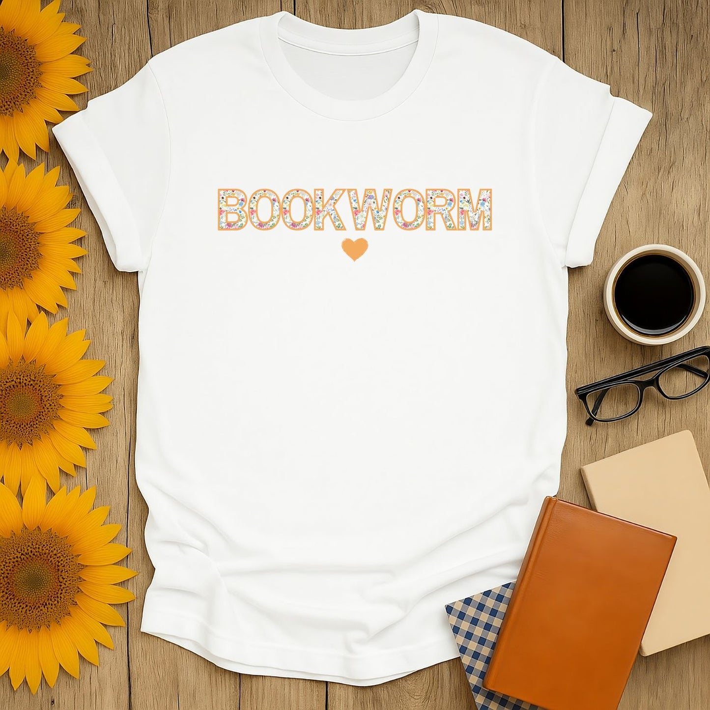 Cozy, white bookworm t-shirt with floral lettering and a heart, perfect gift for cat-loving readers who enjoy coffee or tea.