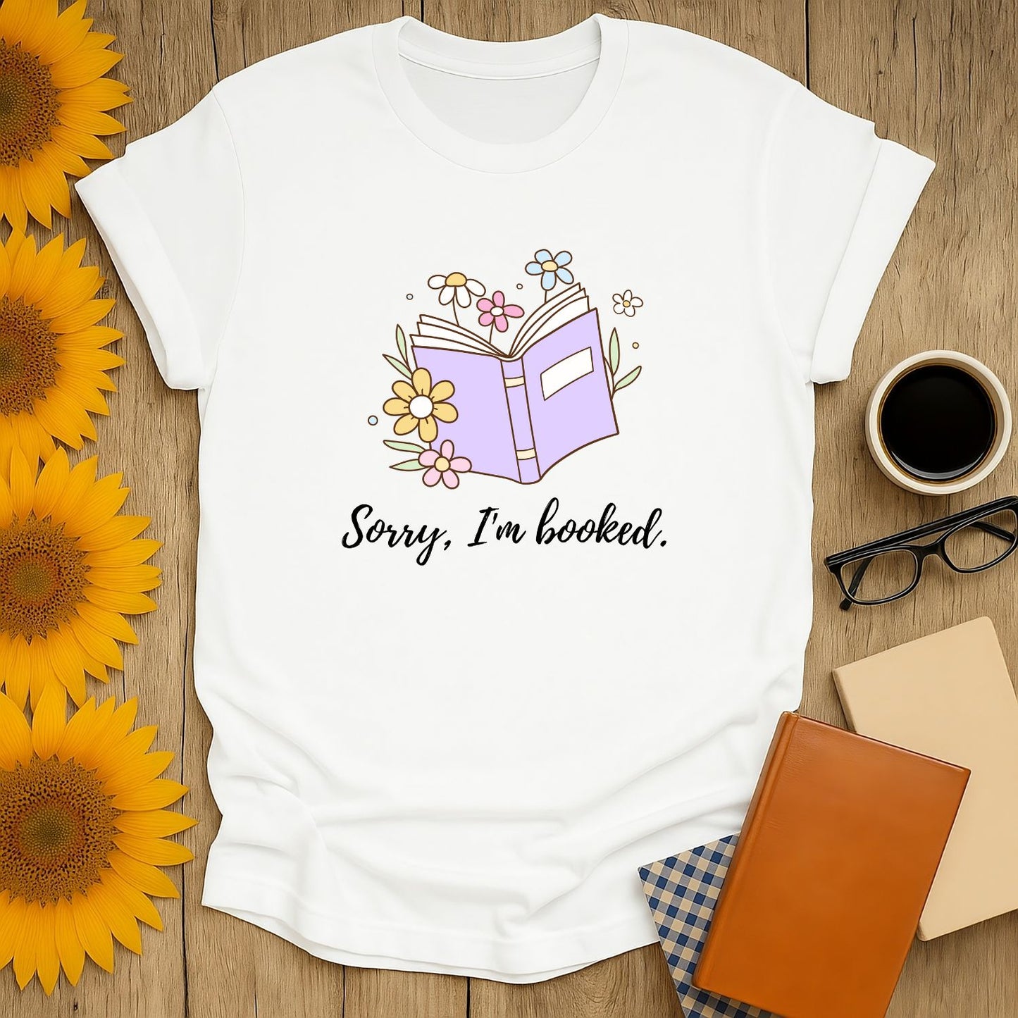 Cozy book lover shirt featuring an open book illustration with flowers and the text 'Sorry, I'm booked.' Perfect gift for readers!