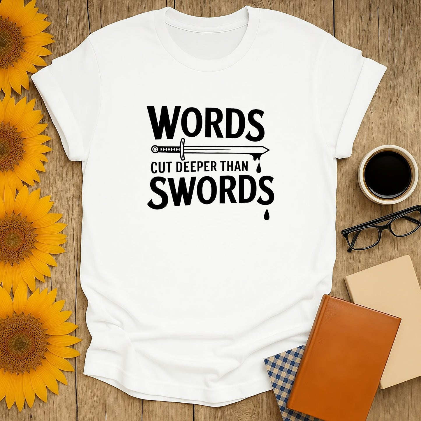 Cozy white t-shirt with 'Words Cut Deeper Than Swords' graphic, perfect for book lovers who enjoy cats, coffee, and tea.