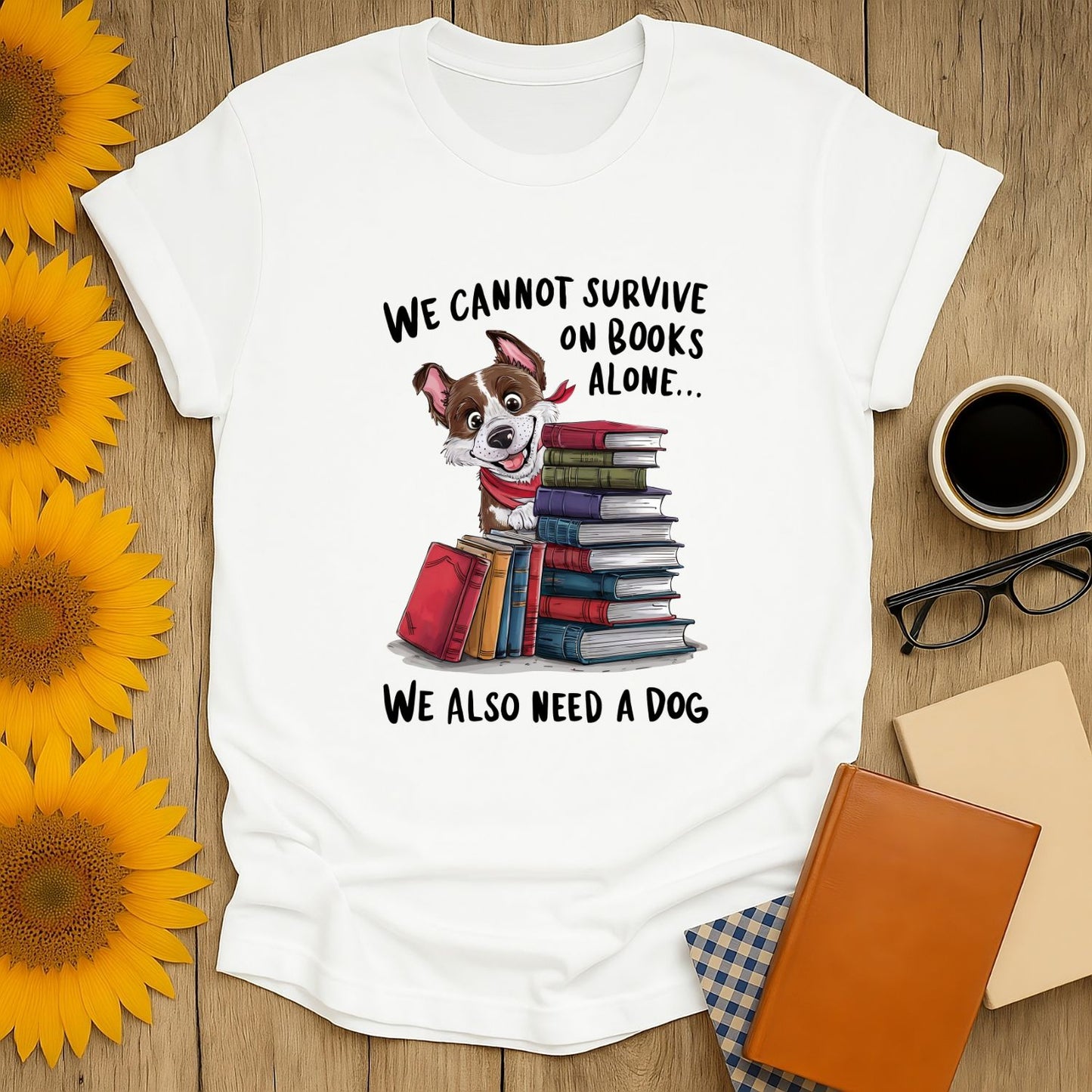 Funny reading tee featuring a dog amidst books, saying "We cannot survive on books alone... We also need a dog" - perfect for cozy book lovers!