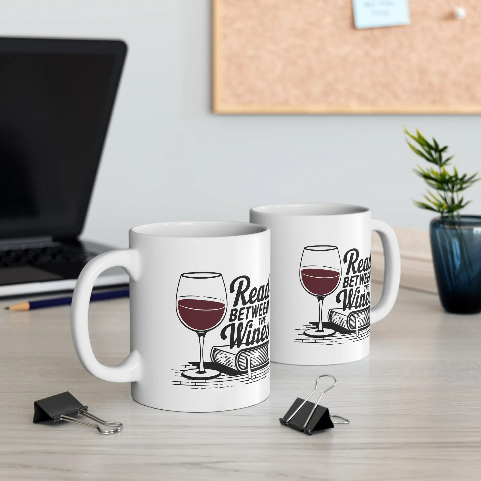 Two Read Between the Wines Mugs featuring a wine glass and playful pun, perfect for book lovers enjoying cozy nights.