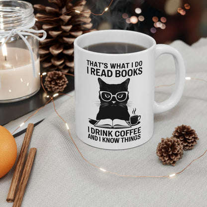 Coffee & Cat Wisdom Mug featuring a black cat in glasses with text: 'That's what I do I read books I drink coffee and I know things'.