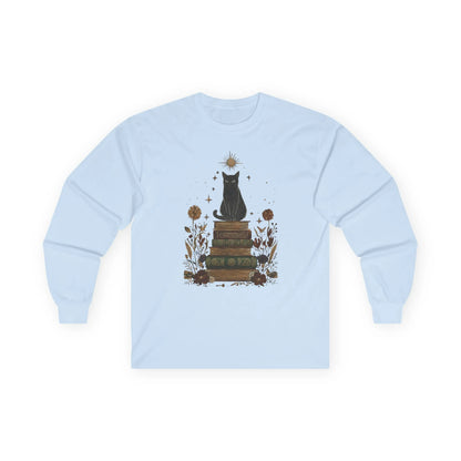 Mystic Cat & Books Long Sleeve features a celestial black cat atop vintage books with star and floral accents, perfect for book lovers.