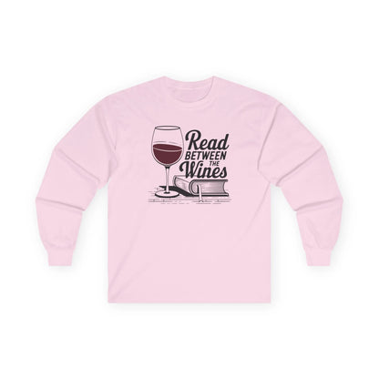 Read Between the Wines Long Sleeve in pink, cozy long sleeve shirt for book lovers with wine glass and book graphic.
