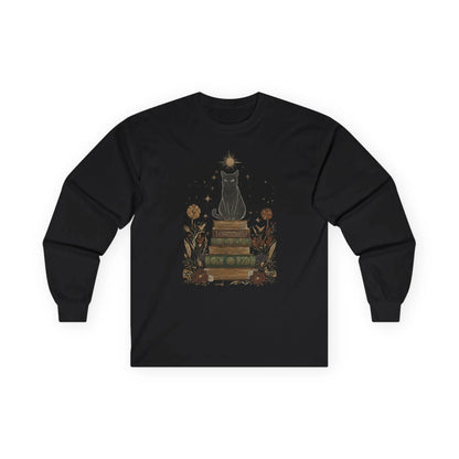 Illustration of a mystical black cat atop vintage books with celestial elements on the Mystic Cat & Books Long Sleeve, perfect for book lovers.