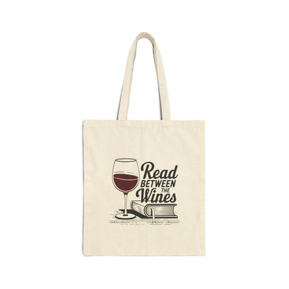 Read Between the Wines Tote Bag featuring a wine glass above stacked books, perfect for cozy reading moments and a glass of red.