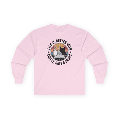 Sunset Reads & Whiskers Long Sleeve in pink featuring a design of a cat, coffee, and books for cozy reading.