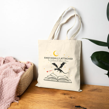 Fictional Characters Tote Bag featuring a graphic of a dragon over an open book, perfect for book lovers.