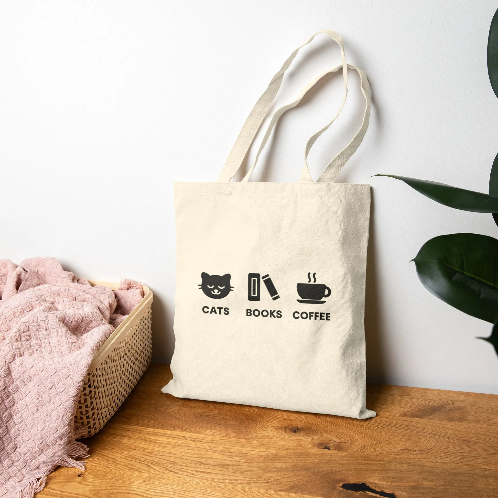 Holy Trinity Tote Bag featuring cute icons of a cat, books, and coffee, perfect for book lovers and cozy life enthusiasts.
