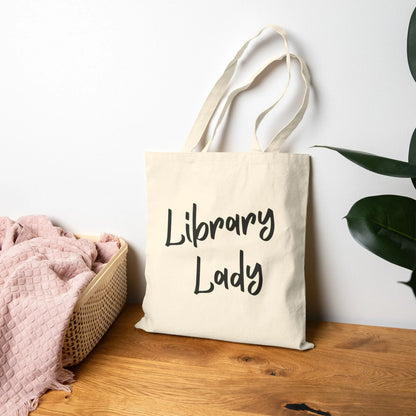 Library Lady Tote Bag with charming handwritten-style typography, perfect for book lovers, coffee and tea enthusiasts.