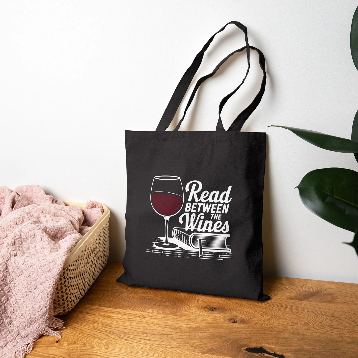 Read Between the Wines Tote Bag featuring a wine glass illustration, perfect for book lovers and a delightful gift for readers.