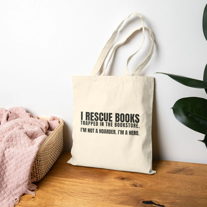 I Rescue Books Tote Bag featuring bold typography saying 'I'm not a hoarder, I'm a hero' for book lovers.