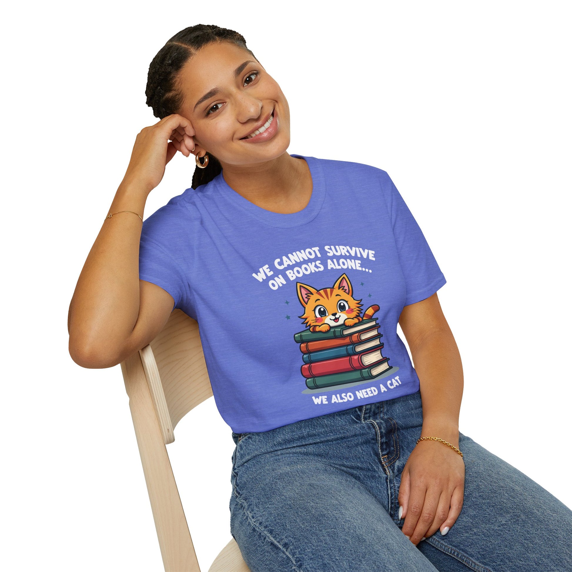 Cozy blue tee with a cute cat on books, text: 'We cannot survive on books alone... we also need a cat.' Perfect for book lovers!