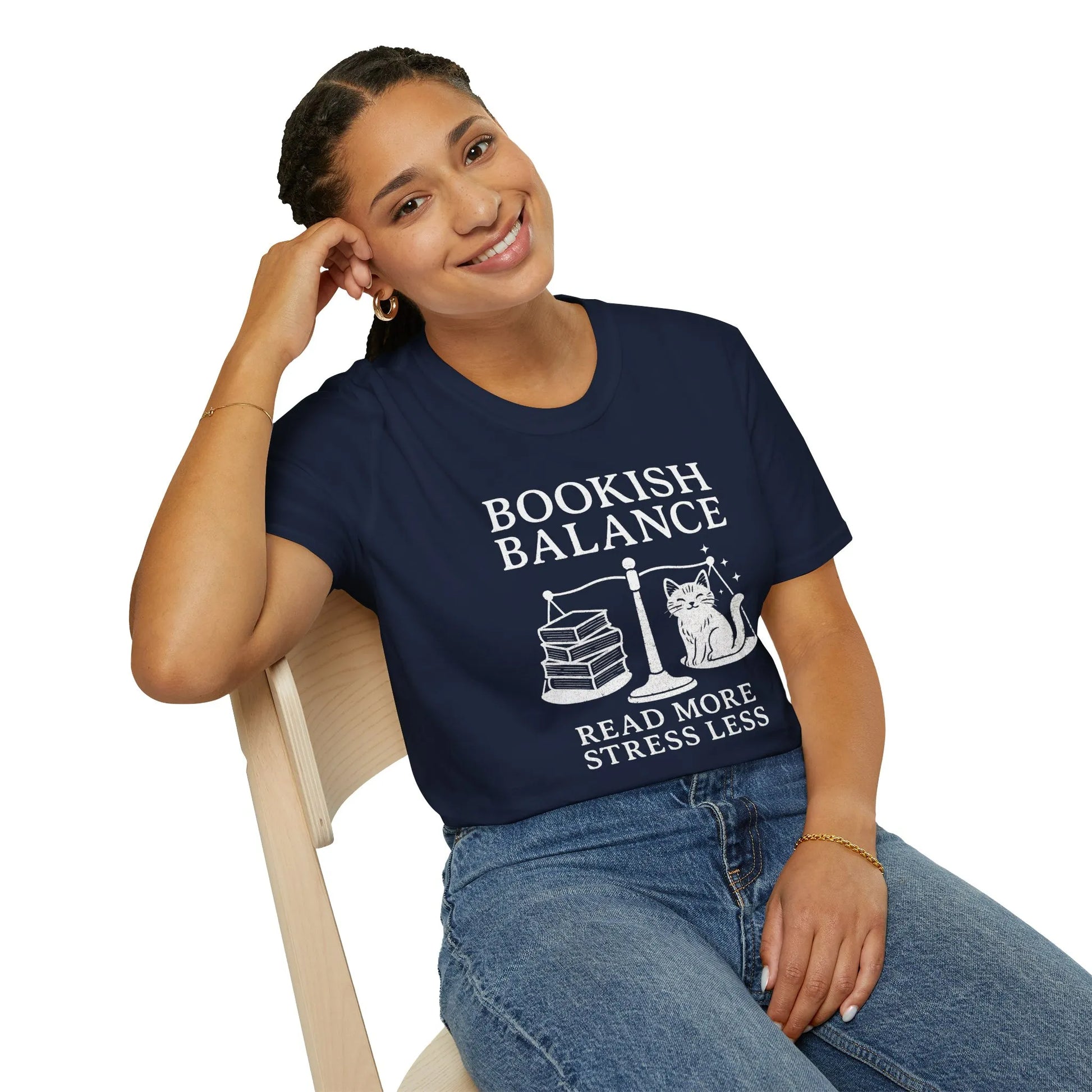 Bookish Balance T-Shirt featuring a charming cat, scales, and text 'Read More Stress Less' for cozy book lovers.