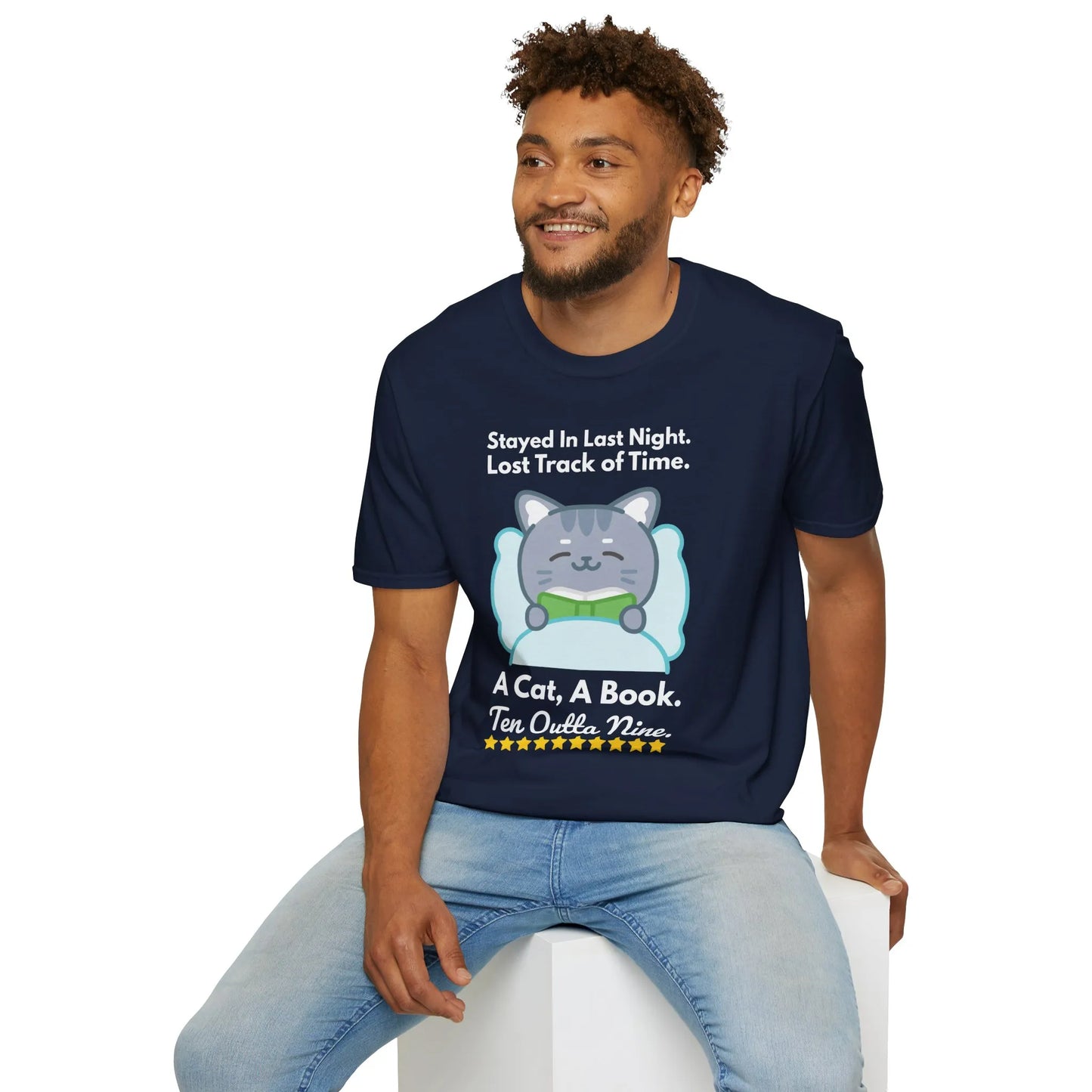 Men's navy t-shirt with playful cat illustration and text 'Stayed in Last Night. Lost Track of Time. A Cat, A Book. Ten Outta Nine.'