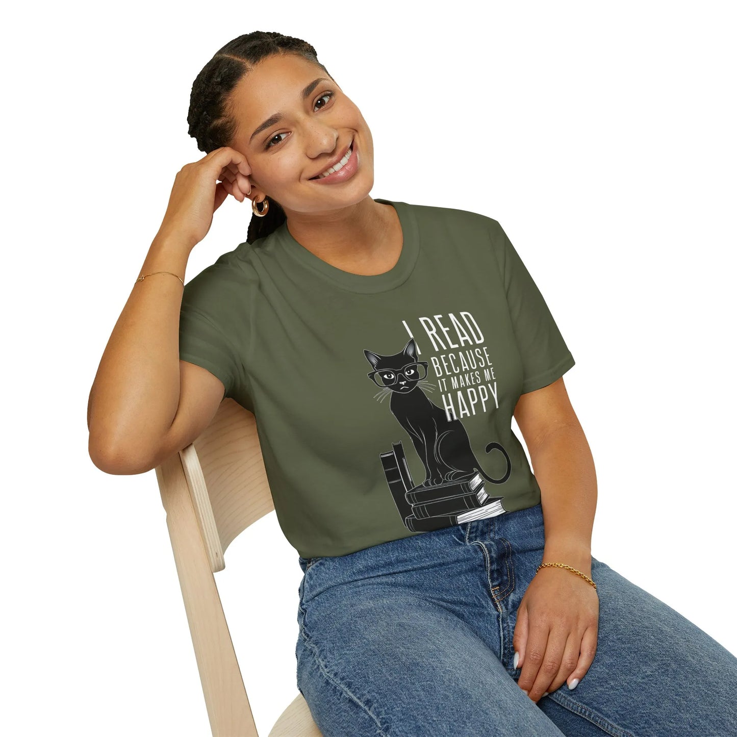 A woman smiles while sitting in a cozy nook, wearing the Happy Reading Kitty T-Shirt, a perfect gift for book lovers.