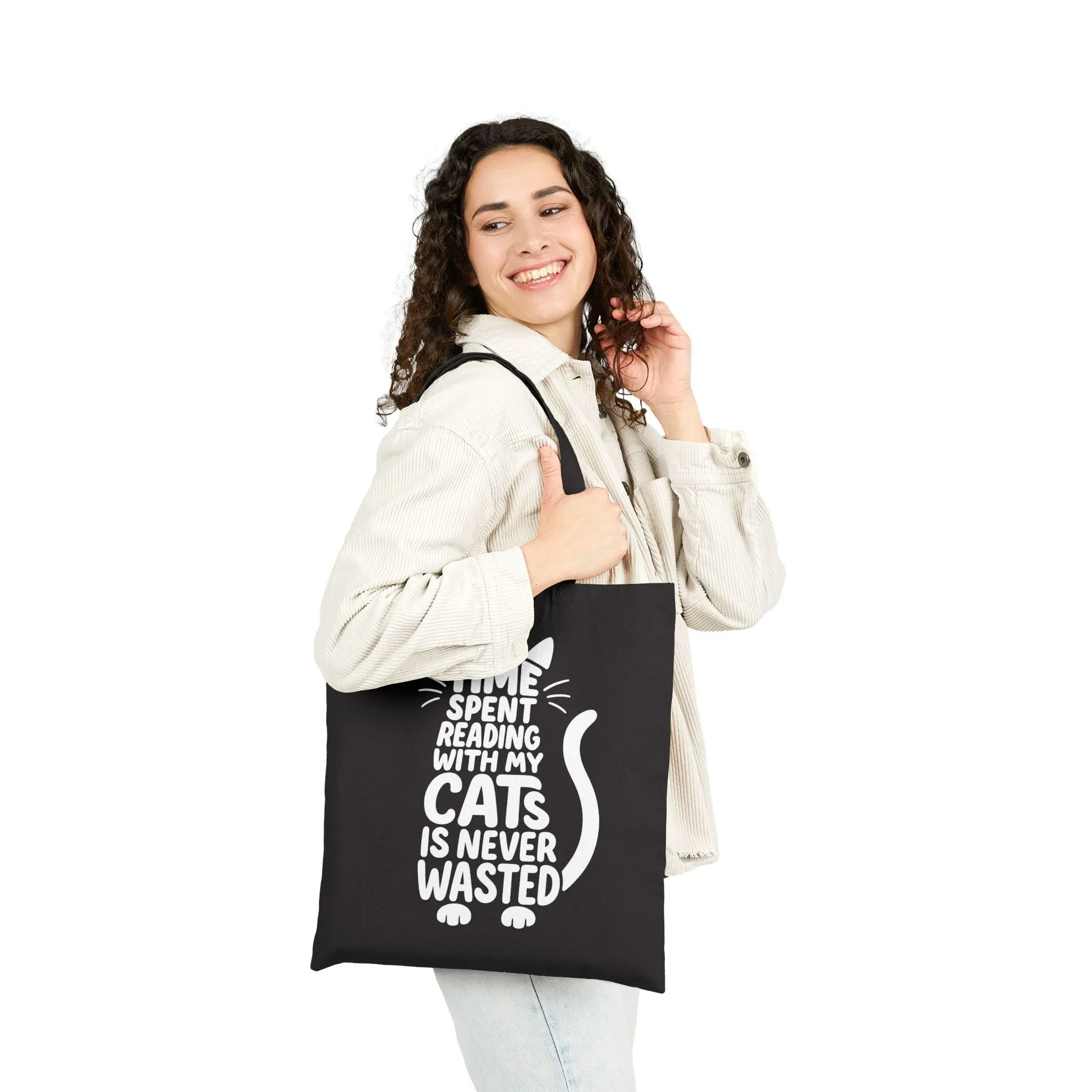 A joyful person demonstrates the Never Wasted with Cats Tote Bag featuring playful cat typography celebrating reading.