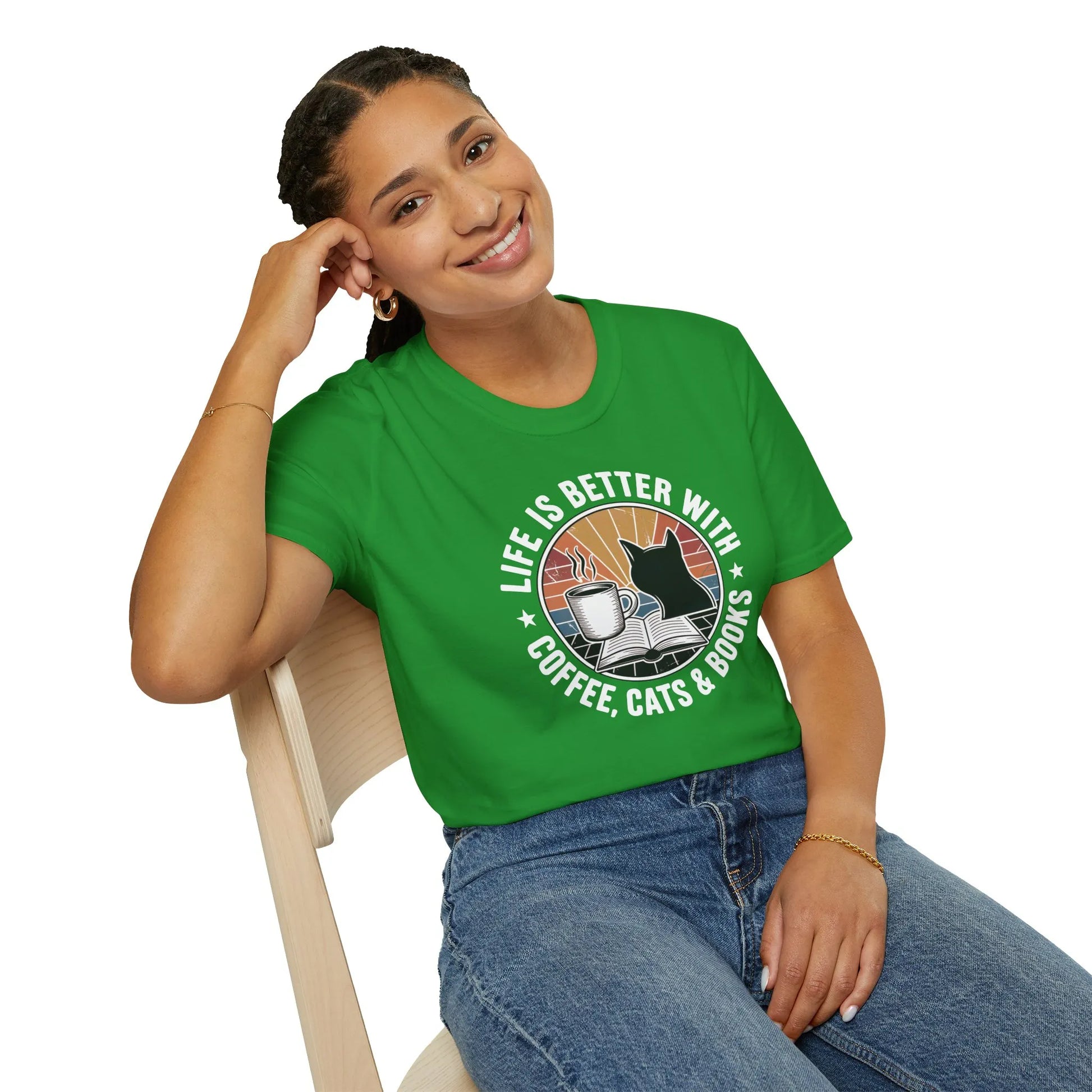 Cheerful woman in a green t-shirt with ‘Life is Better with Coffee, Cats & Books’ design, perfect cozy gift for book lovers.