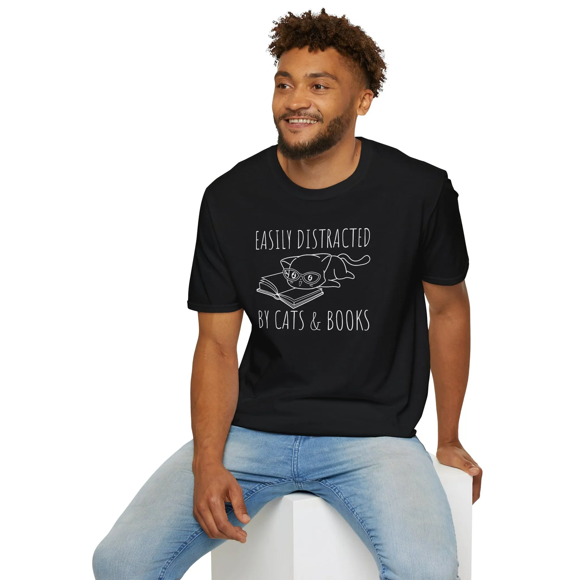 Fun black t-shirt with a cat lounging on a book and the text 'Easily Distracted by Cats & Books' - perfect gift for book lovers.
