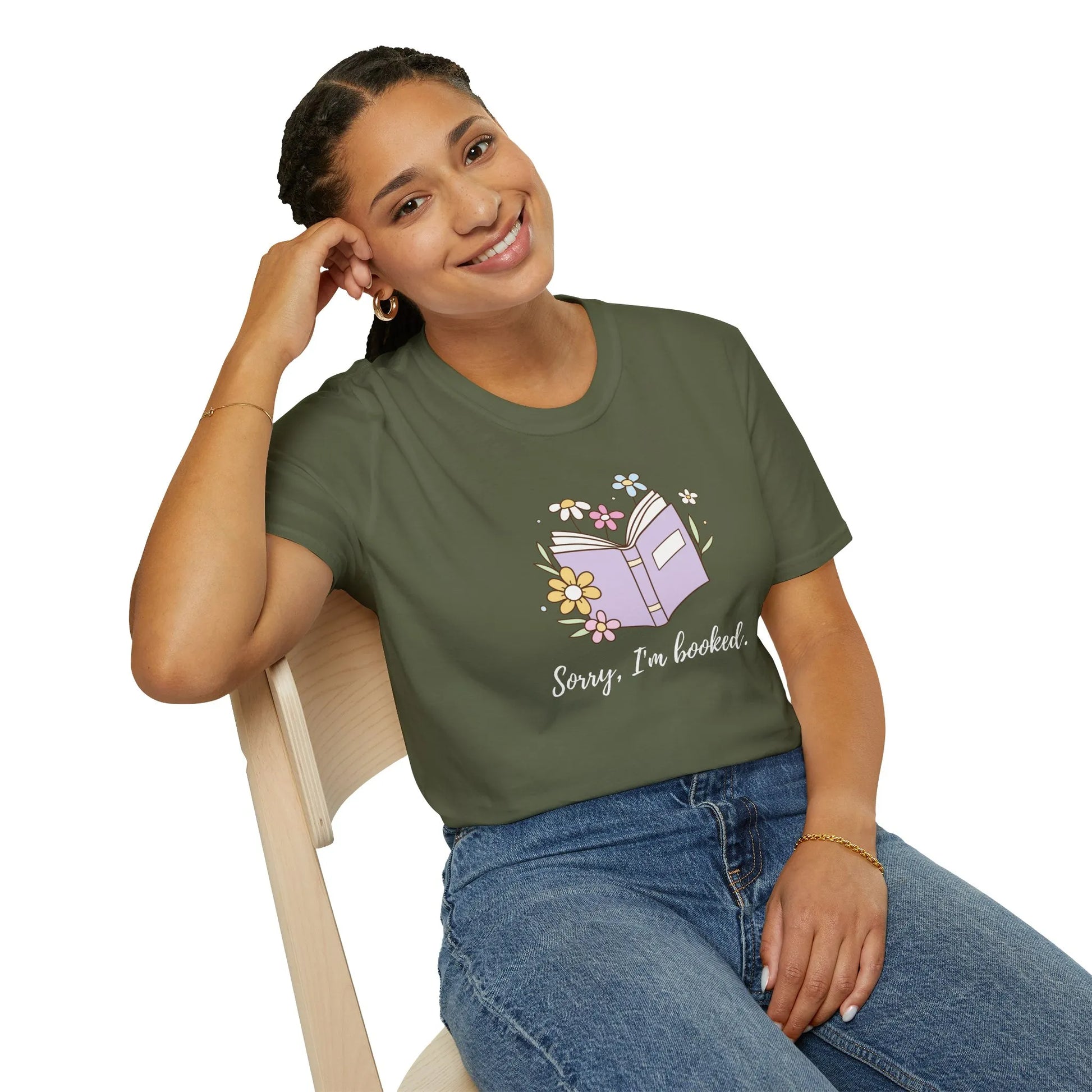 Woman in cozy organic cotton t-shirt with 'Sorry, I’m Booked' print, floral design, perfect for book lovers 📖.