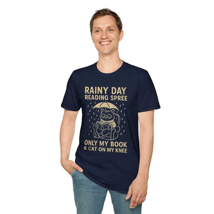 A smiling man in a navy tee featuring a cute cat under an umbrella and the text 'Rainy Day Reading Spree'—perfect for cozy reading enthusiasts.