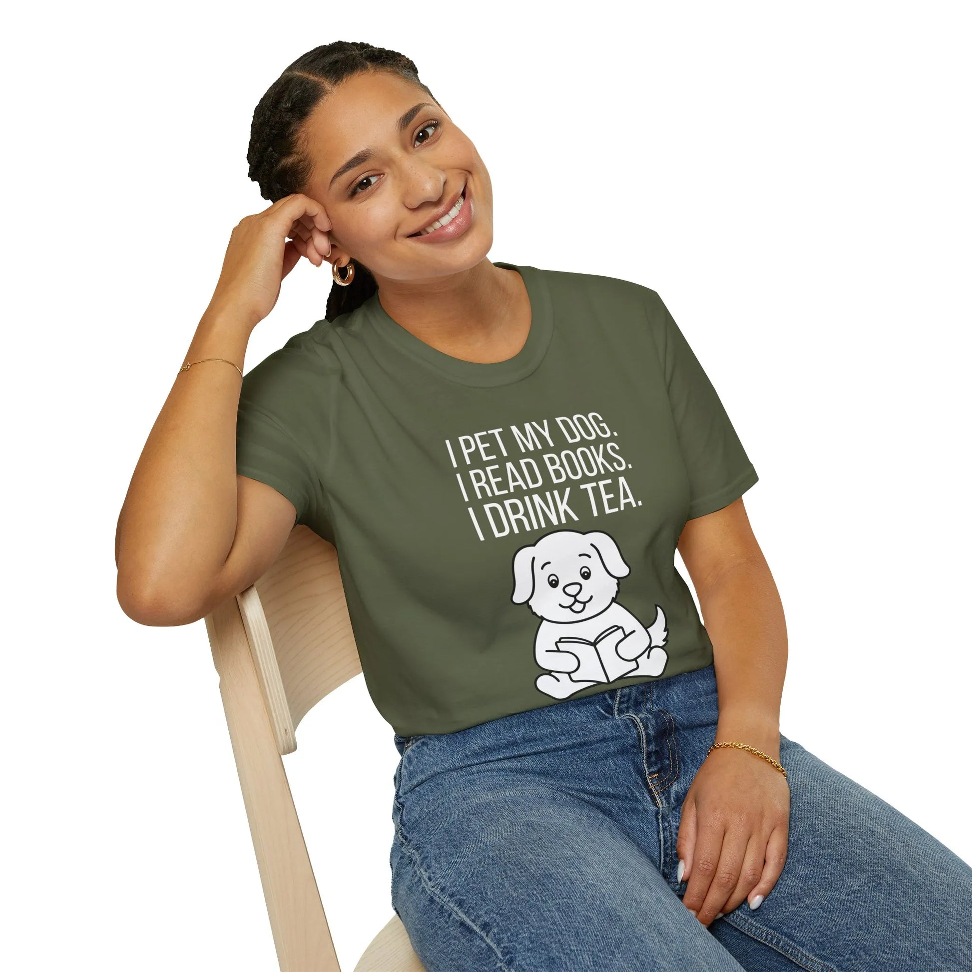 A relaxed fit Tea, Tales & Tail Wags T-Shirt worn by a smiling woman, sharing her love for dogs and books in a cozy reading nook.