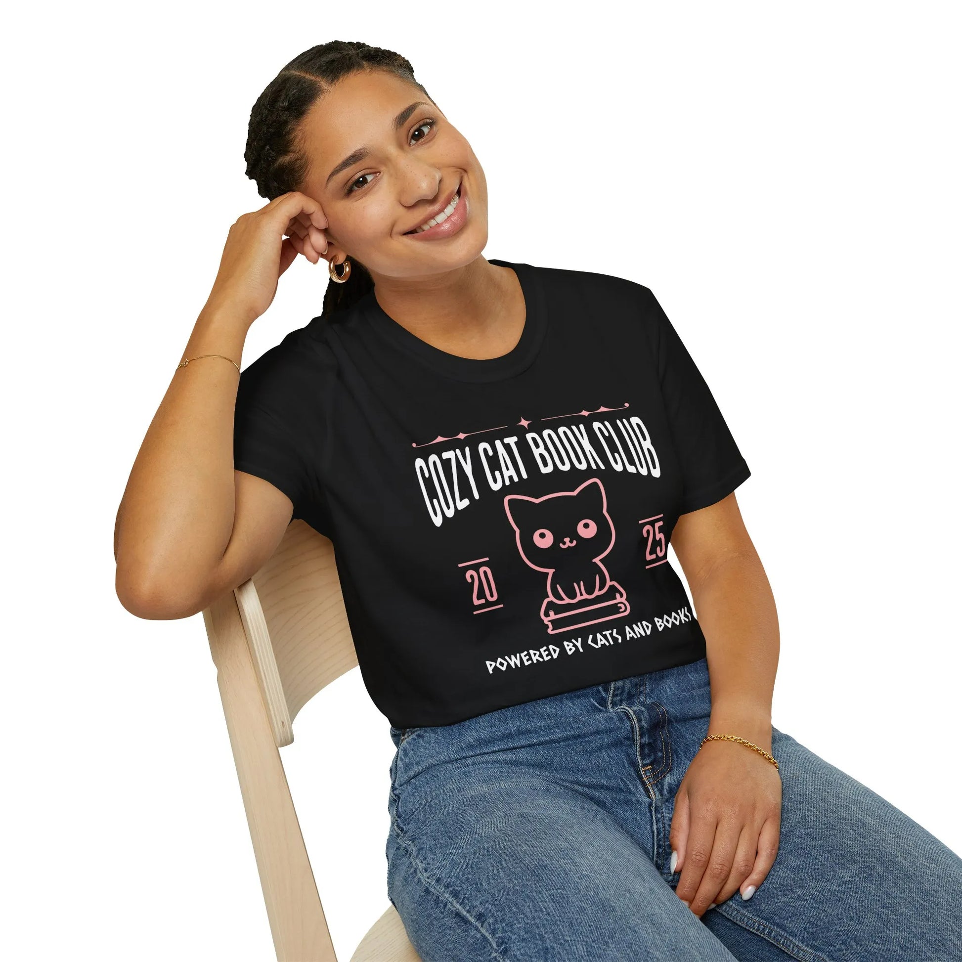 Smiling person wearing a Cozy Cat Book Club T-Shirt with a cute kitty illustration, perfect for book lovers who enjoy cozy vibes.