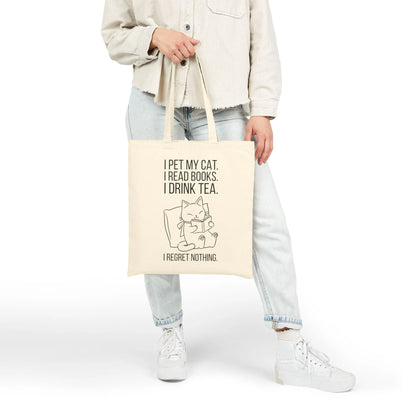 Purrfect Tea & Tales Tote Bag featuring a cat, books, and tea with the text, "I regret nothing." Perfect gift for cat-loving readers!