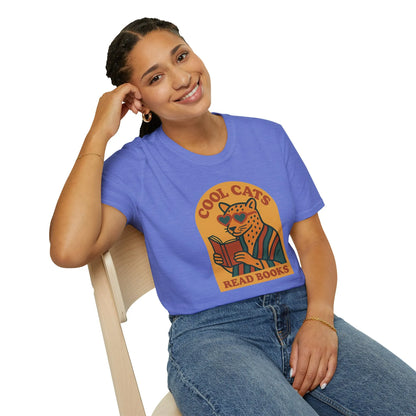 A cheerful person in a blue t-shirt featuring a cool cat reading a book with 'Cool Cats Read Books' text, perfect for book lovers.