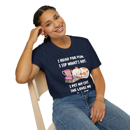 Smiling woman wearing a navy shirt with cat illustrations and text about reading and sipping, perfect for book lovers.