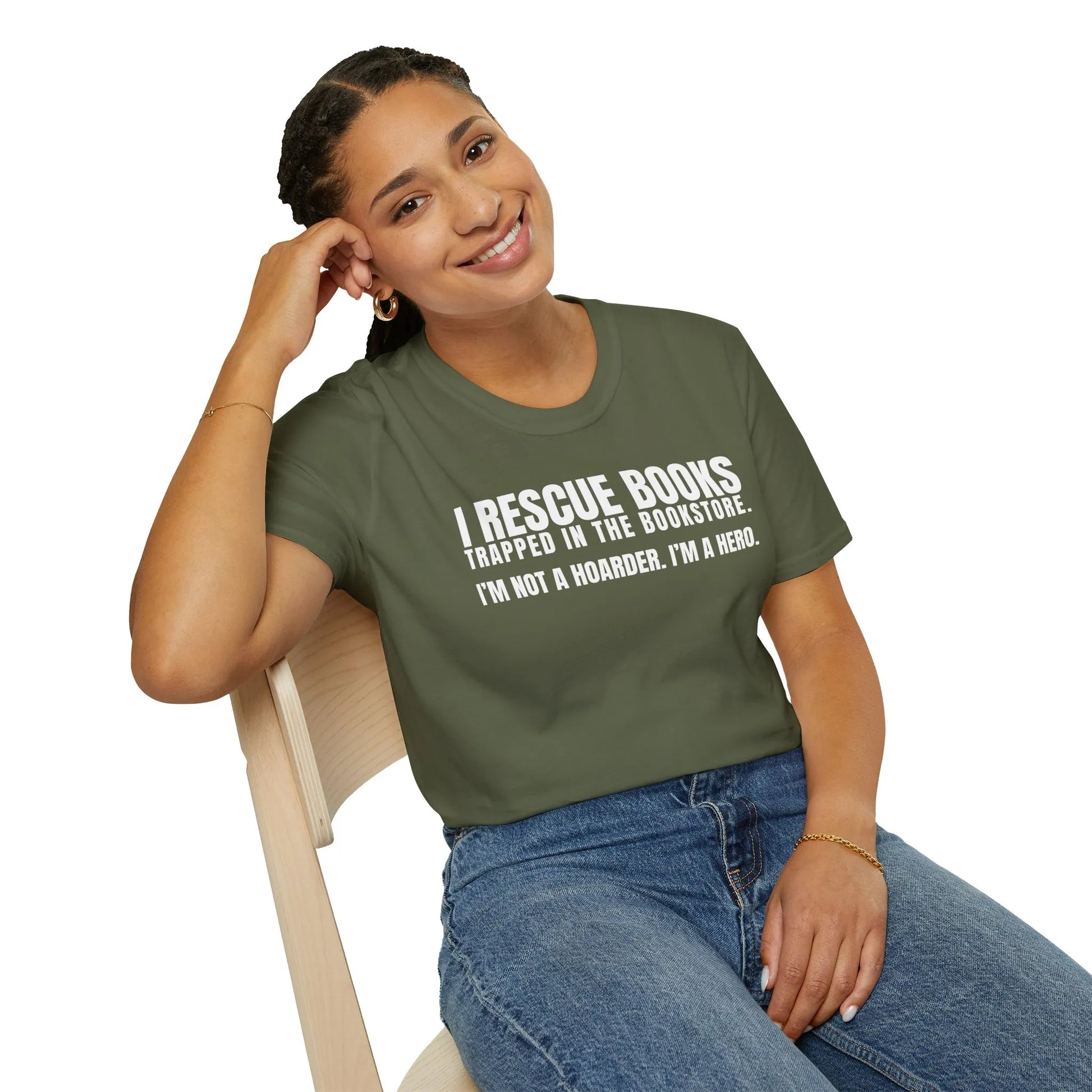 Woman wearing a cozy reading t-shirt, smiling while sitting in a bright book nook, embodying the relaxed lifestyle of a book lover.