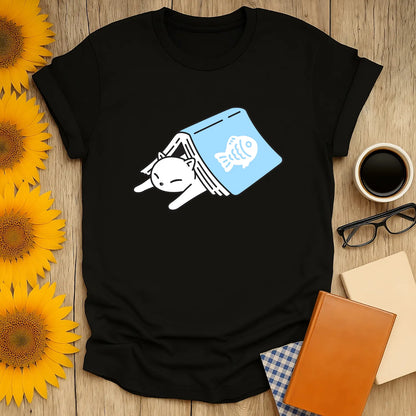 Cozy cat shirt design with a sleepy cat in a book, perfect for book lovers and cat enthusiasts.