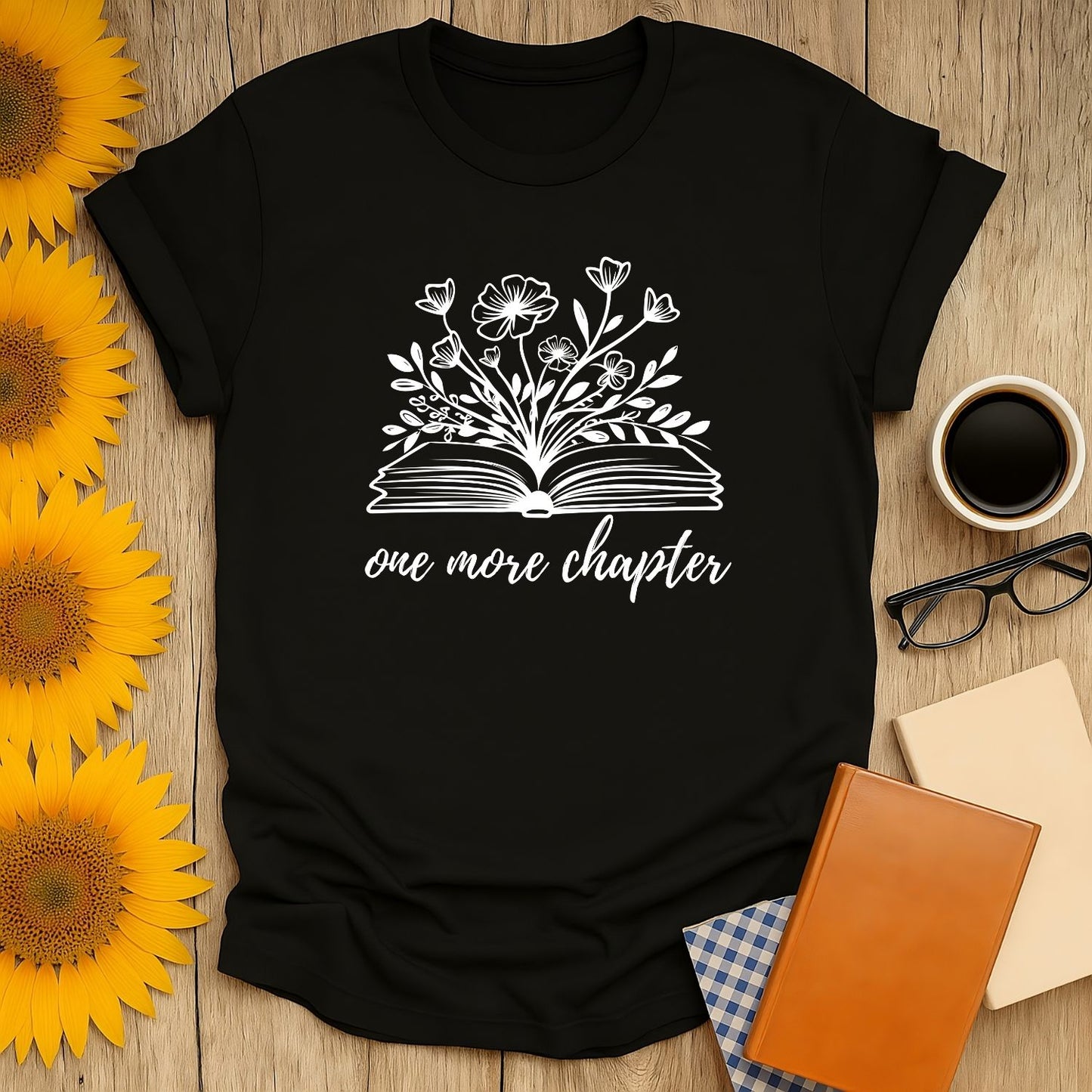 Cozy book lover shirt with an open book design and floral accents, saying 'one more chapter'—perfect for tea and cat enthusiasts!