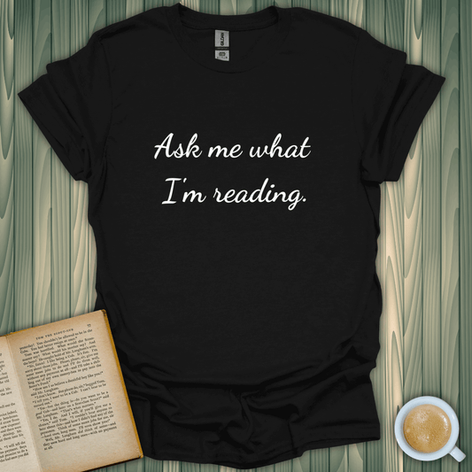 Ask Me T-Shirt design with the text 'Ask me what I'm reading.' Perfect for book lovers. Made of 100% cotton.