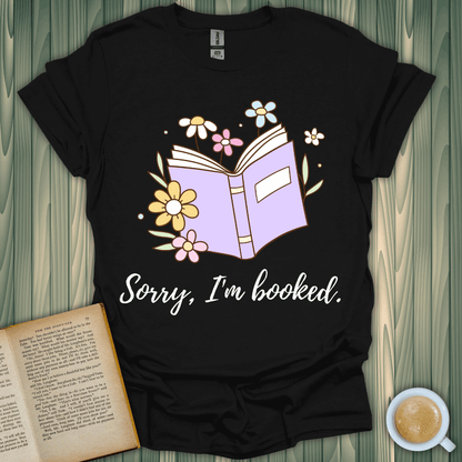 Sorry, I’m Booked t-shirt design featuring an open book and flowers, perfect for book lovers.