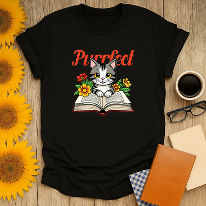 Purrfect Page T-Shirt features a cute kitten on a book with flowers, perfect for book lovers and cozy reading outfits. 📖