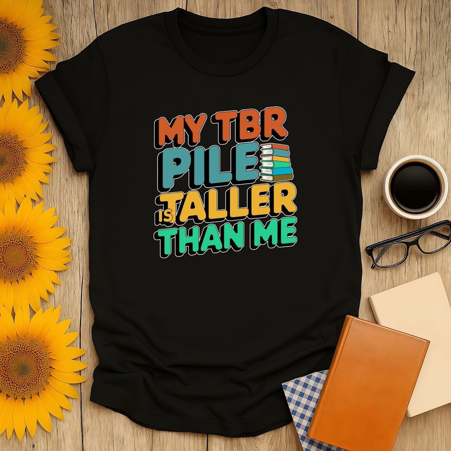 Black unisex T-shirt with 'My TBR Pile is Taller Than Me' text, perfect for book lovers who enjoy cozy reading vibes.