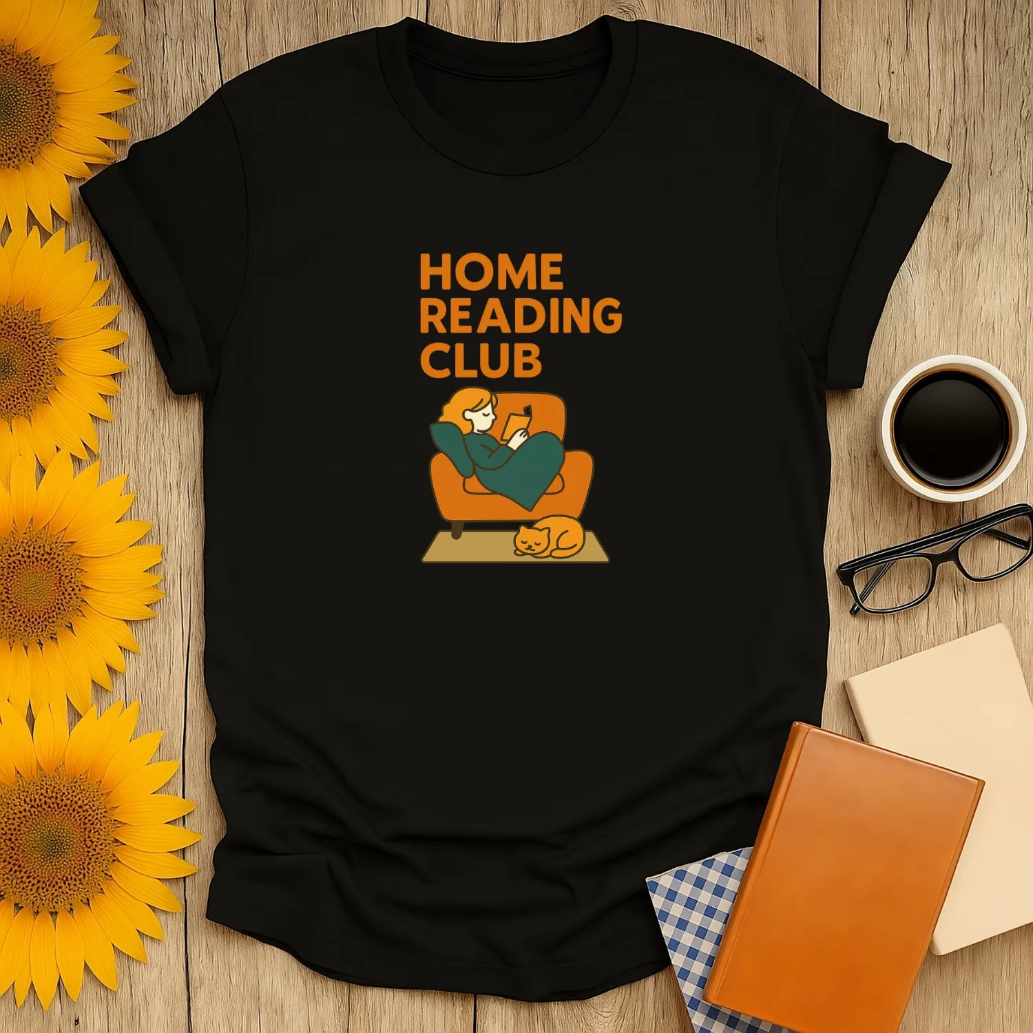 Cozy black tee with "Home Reading Club" text and illustration of a person reading on a couch with a cat. Perfect for book lovers!