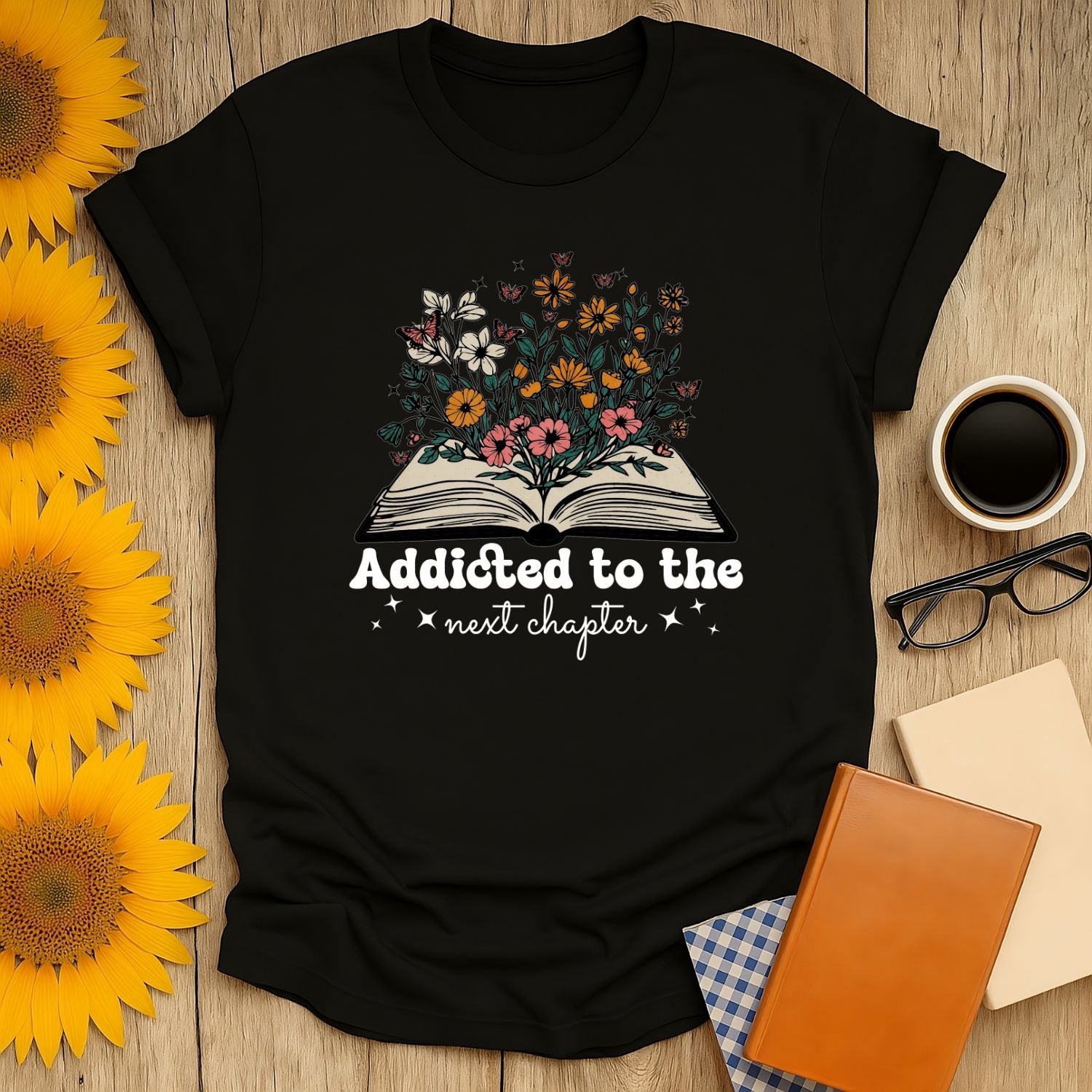 Addicted to the next chapter t-shirt featuring flowers and an open book, perfect gift for book lovers who enjoy cozy reads, cats, and coffee.