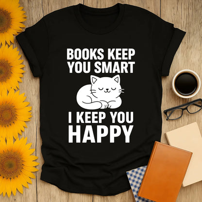 Cozy black t-shirt featuring a sleeping cat and text: 'Books Keep You Smart, I Keep You Happy' for book lovers.