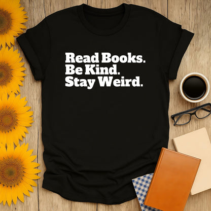 Cozy black t-shirt with 'Read Books. Be Kind. Stay Weird.' text. Ideal gift for book lovers who adore cats, coffee, and tea.