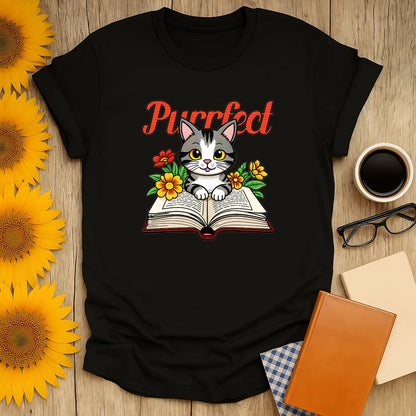 Cute cat on an open book surrounded by flowers, perfect for book lovers and cat enthusiasts alike. Cozy reading tee!